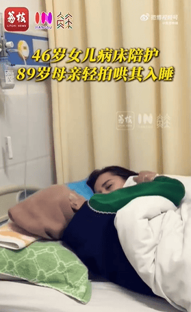 女子下班后到医院陪护母亲，疲惫趴在床边睡去，母亲轻拍其后背